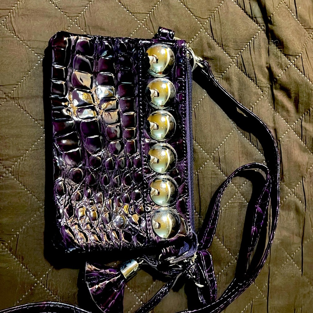 Crocodile patterned shiny purple clutch bag.